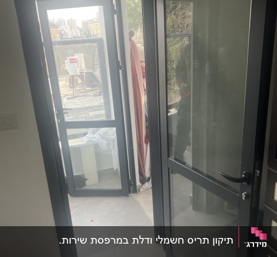 דלת אלומיניום כהה משולבת זכוכית המותקנת בדירה